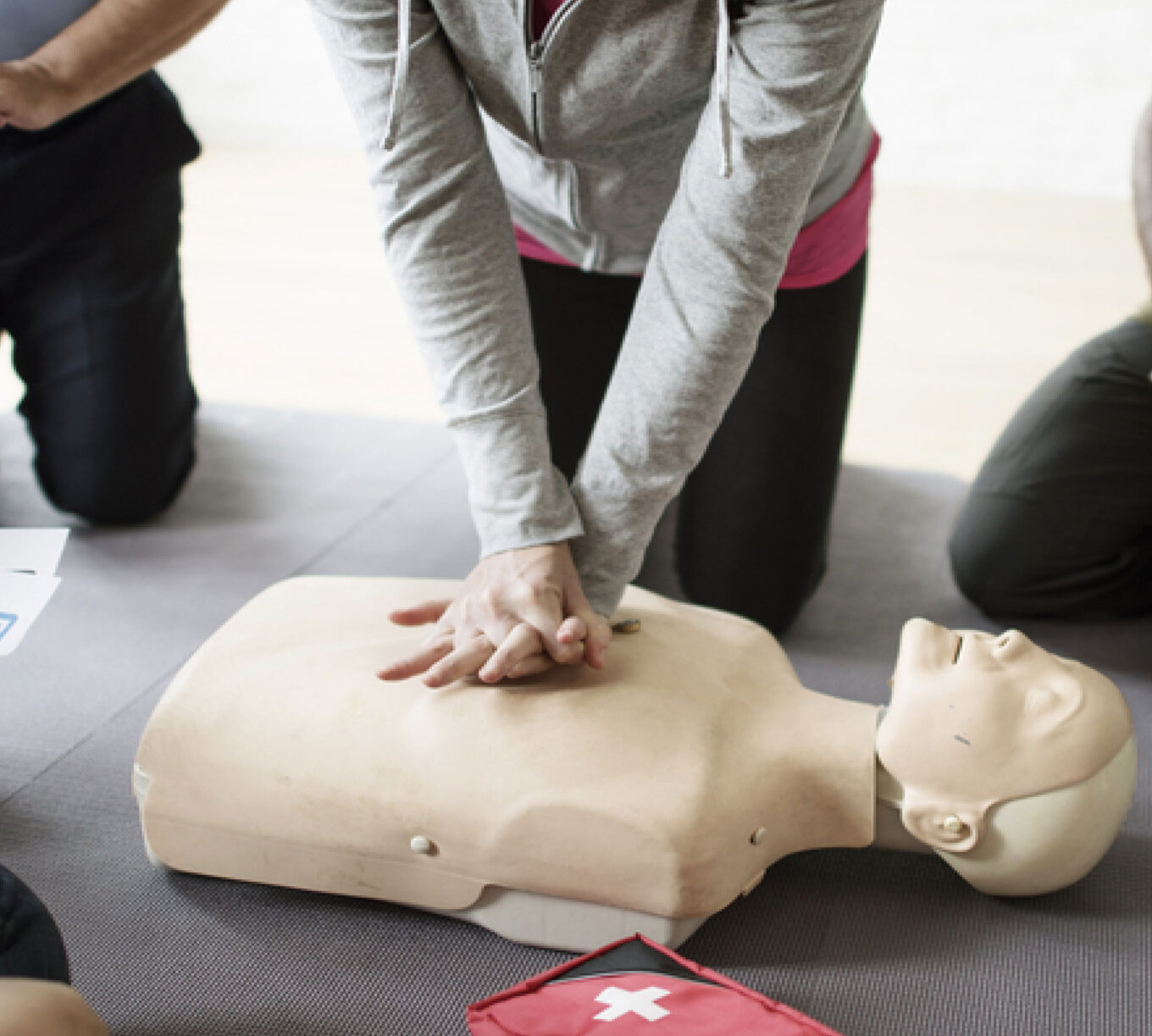 Learner practising chest compressions on a first aid training mannequin